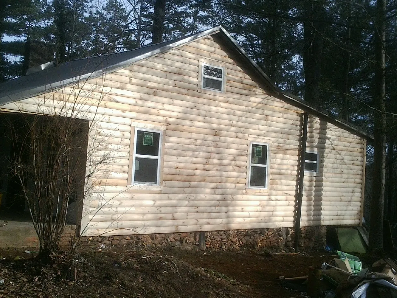 New log siding and dark metal roofing on a gable end in Putnamville