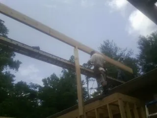 Carpenter setting a ridge beam over a new addition frame — Ice Dam Removal by Roofing Brothers in Putnamville