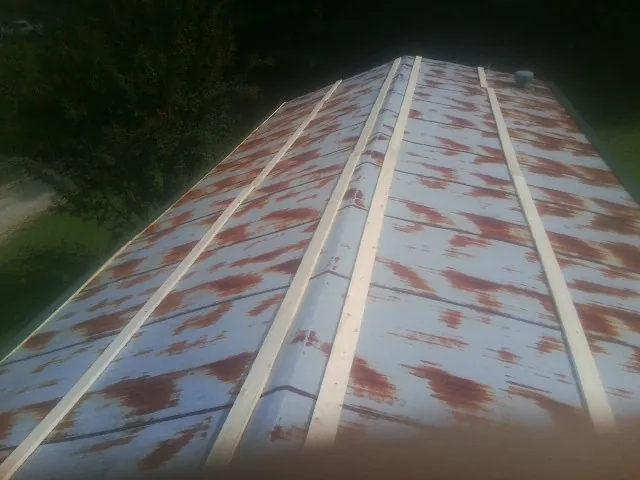 Rusted metal roof panels with new wood purlins before replacement — Storm Damage Roof Repair in Putnamville by Roofing Brothers