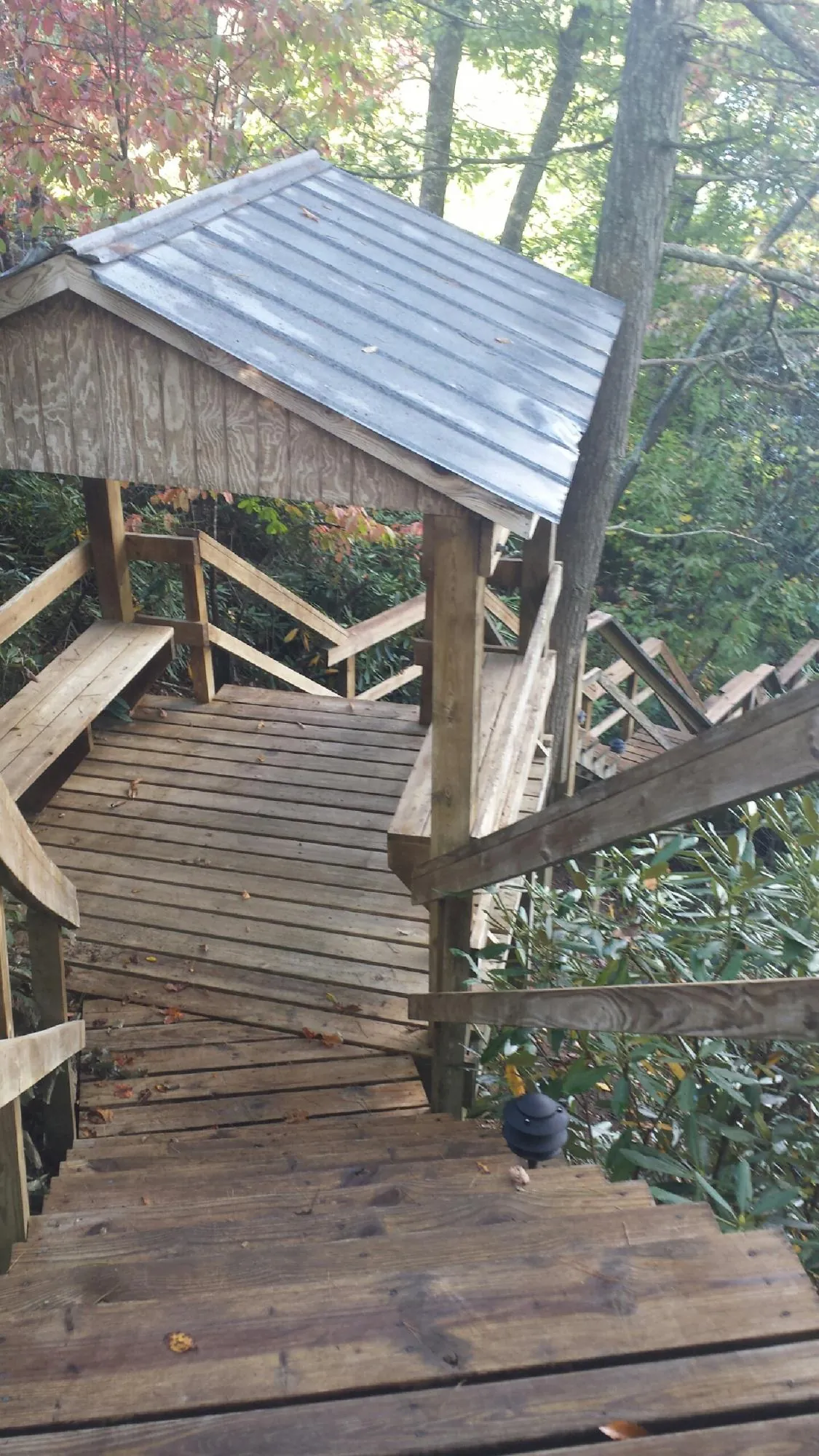 Metal roofed shelter over wooden steps on a wooded walkway — Skylight Repair & Installation work by our crew in Putnamville