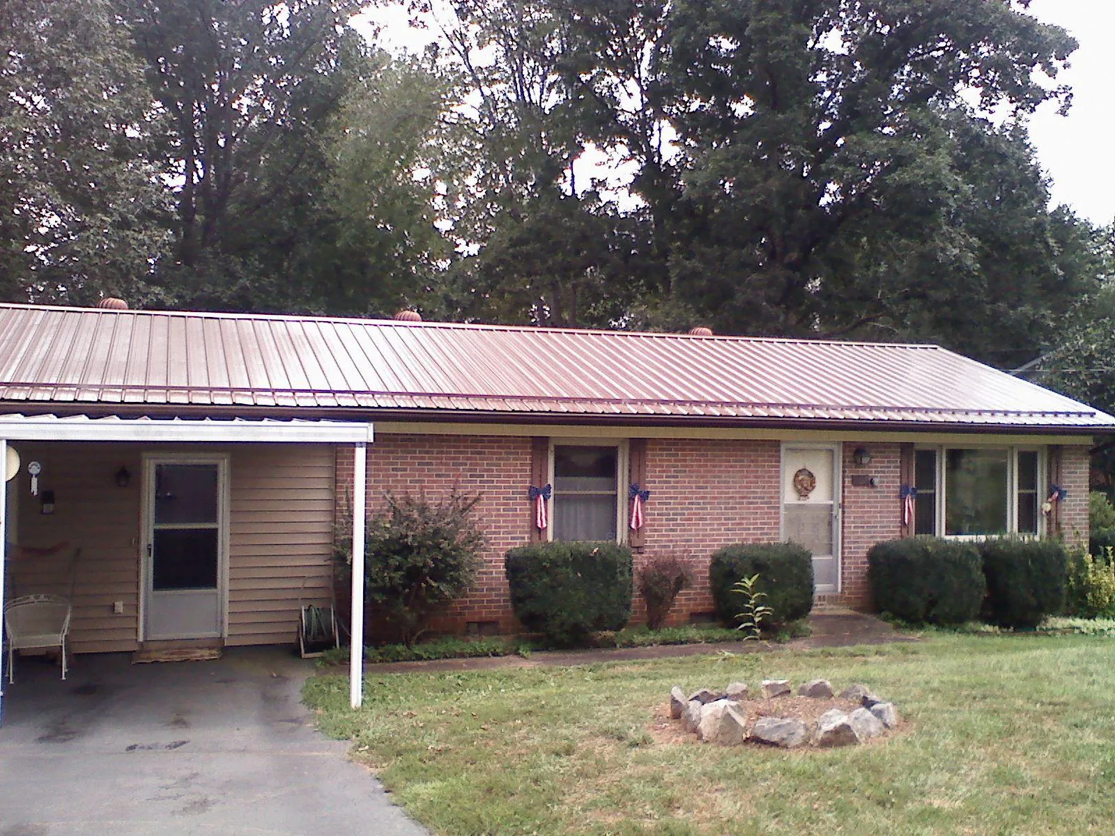 Bronze metal roof and carport on a brick ranch home — Roof Repair work by our crew in Putnamville